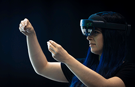 Young woman wearing a VR headset playing against a green screen