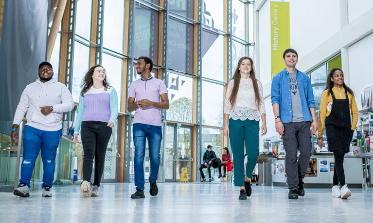 A group of multinational students walking into the bright foyer of the Herbert Art Gallery and Museum in Coventry.