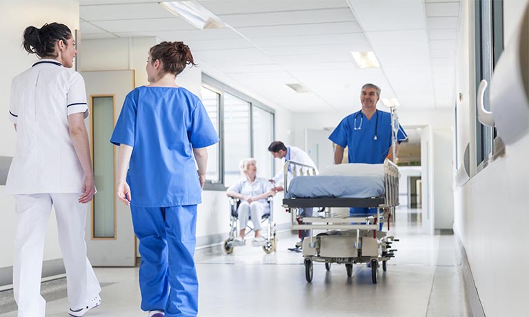 nurses and doctors walking through a corridor