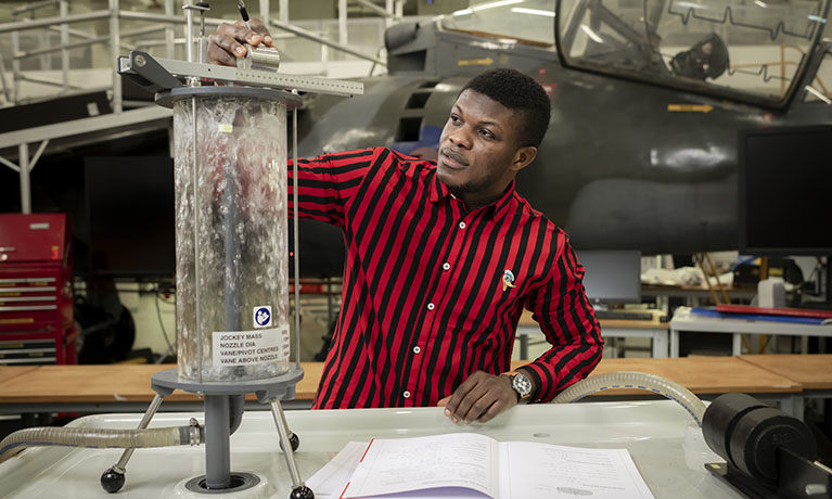 Student using aerospace equipment with the harrier jet in the background