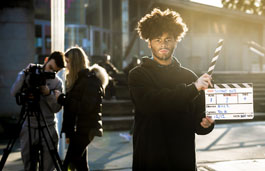 Media student holding a clapperboard