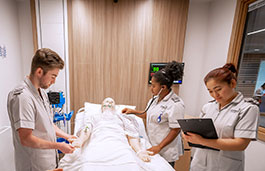 Students working on a manikin in the hospital ward