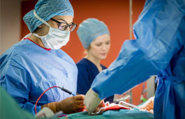 Students in scrubs in a mock operation scenario in the operating theatre