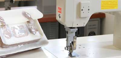 close up image of sewing machine and prototype handbag