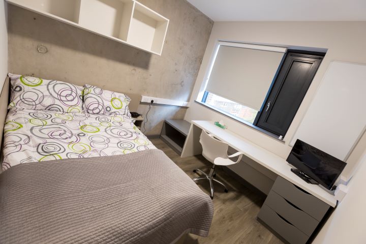 Double bed and desk with chair in a room