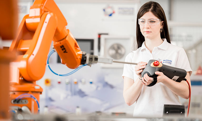 Female student working with a robotic manufacturing machine