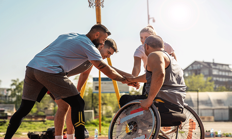 A group of people playing sport including one person in a wheelchair