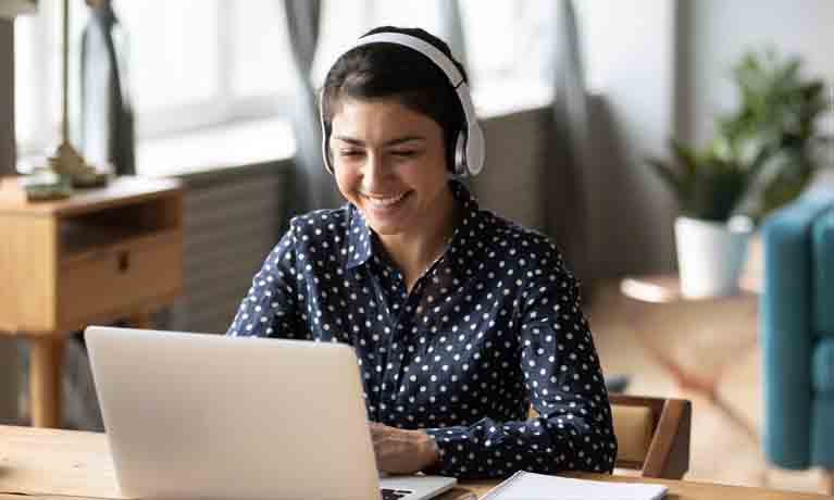 Girl with headphones watching webinar on laptop
