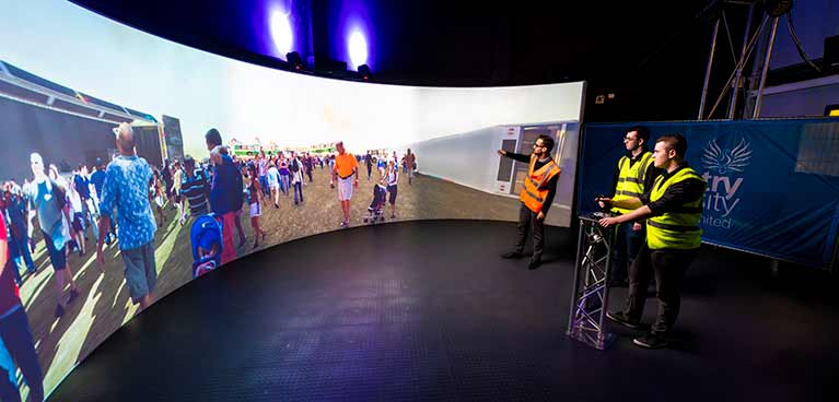 Three people wearing fluorescent jackets in the simulation centre