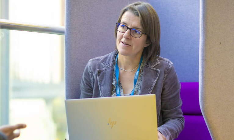 Female advisor smiling sitting in front of laptop