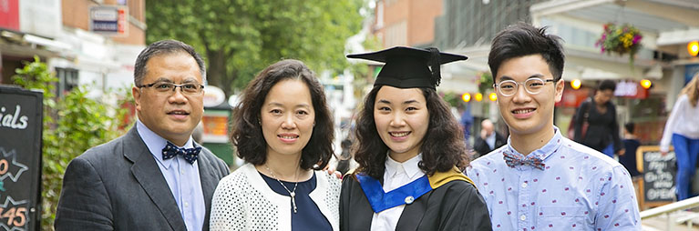 parents and supporters with a student at their graduation