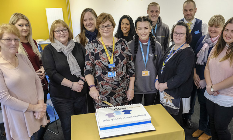 Nursing staff and students cut a celebratory cake