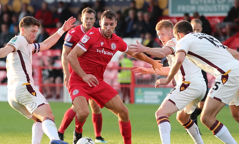 Matt Lowe in action for Accrington Stanley challenging players from an opposition team