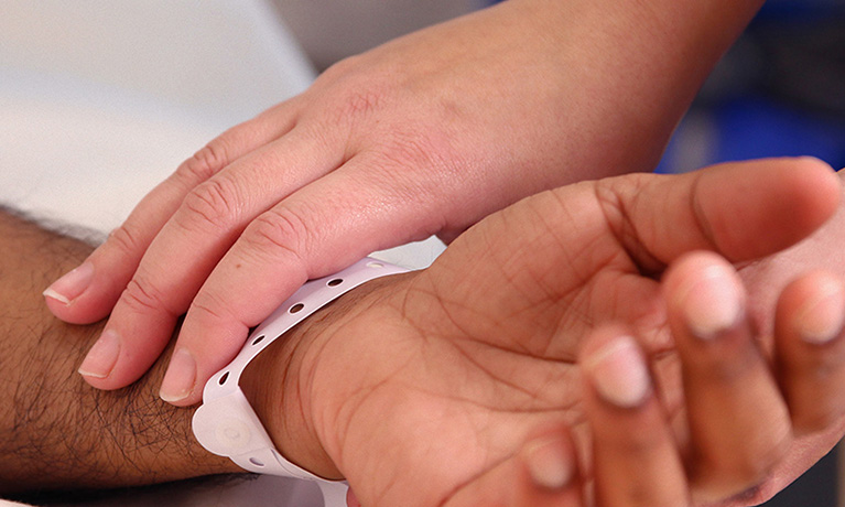 Nurse holding a patients hand