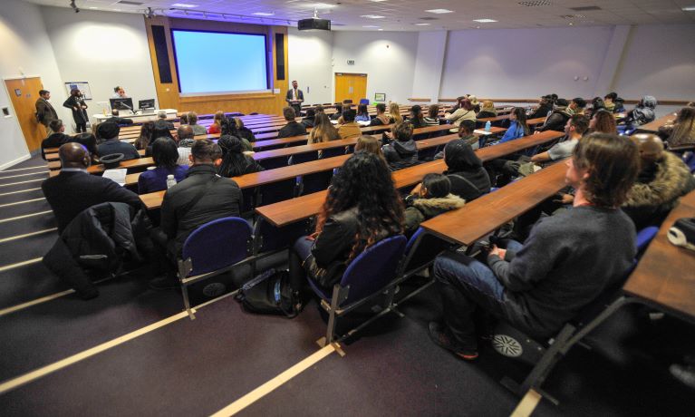 Audience watching a seminar in lecture theatre