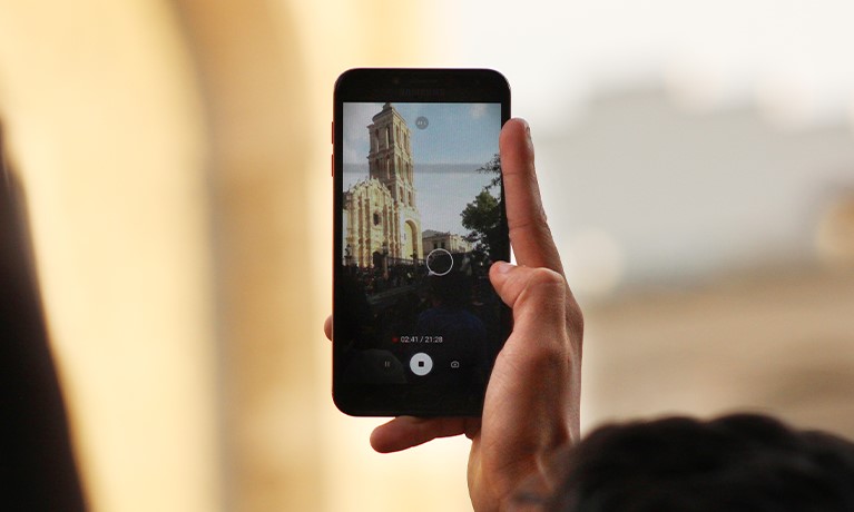 person taking a picture of a cathedral on a phone