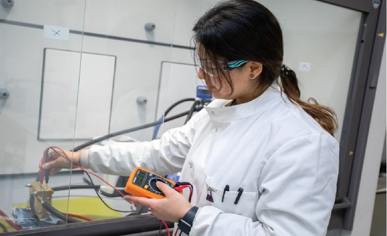 Student in lab coat conducting experiment