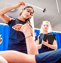 Sports therapy student checking patient's feet