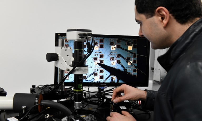 person looking at semiconductor in a white room