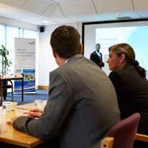 Two colleagues listening to a presentation