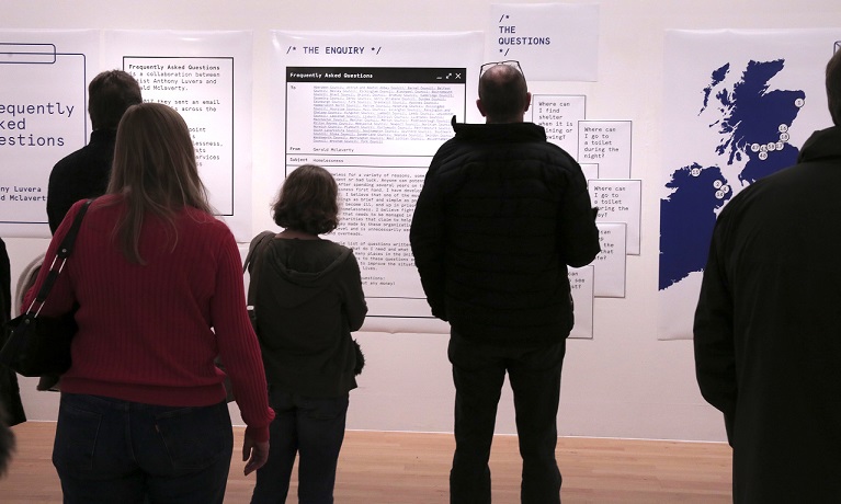 Group of people looking at exhibition posters