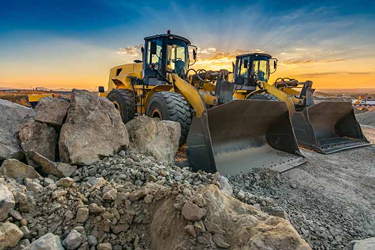 two yellow backhoe loaders