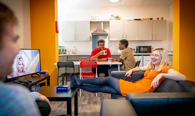 Students in the living and the kitchen area of their accommodation
