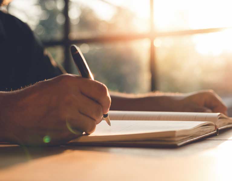 a creative writer making notes in the handbook