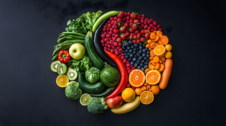 Fruit artistically displayed in a circle against a black backdrop