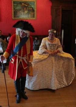 a man and woman dressed as Queen Catherine in old royal clothing