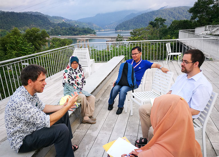 A few attendees of the Kuala Lumpur workshop sitting on a rooftop balcony having a discussion