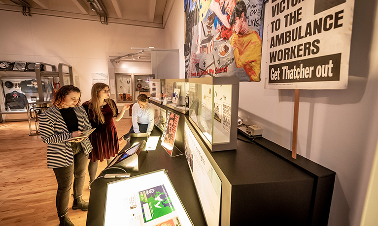 Three students looking at a history exhibition in a museum