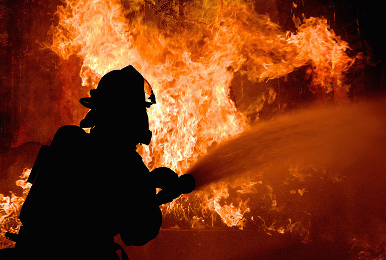 Silhouette of Firemen fighting a raging fire with flames. Forest fire. Silhouette of Firemen fighting a raging fire with flames. Forest fire.