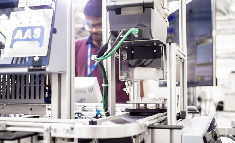 Student operating machinery in a factory workshop