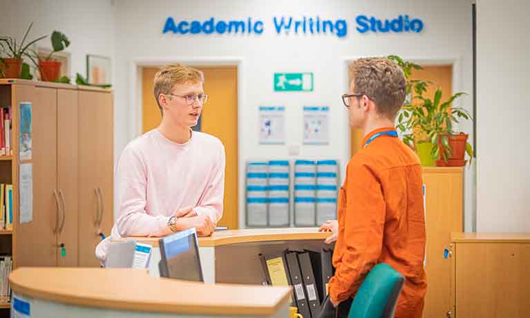 Two students indoors having a discussion