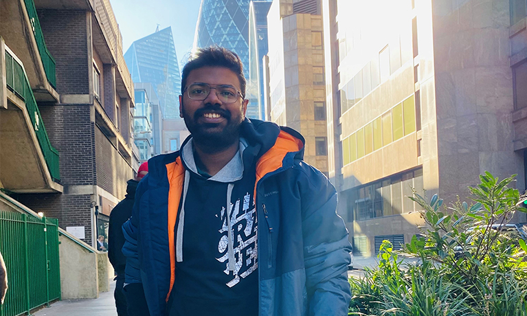 Perin standing in front of business buildings in London