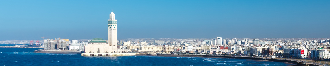 A view of the Casablanca skyline from the sea, against a bright blue sky.