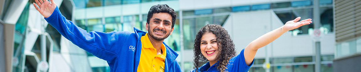 Two students cheerning in front of a building