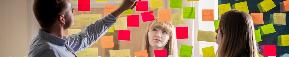 Students sticking post it notes on a whiteboard