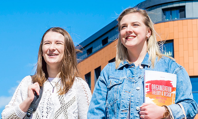 Two students outside their halls of residence accommodation