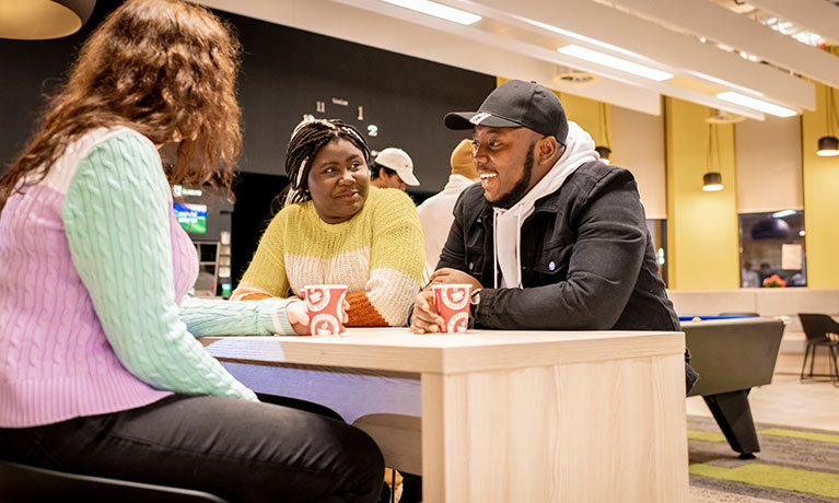 Students laughing and talking in a social space