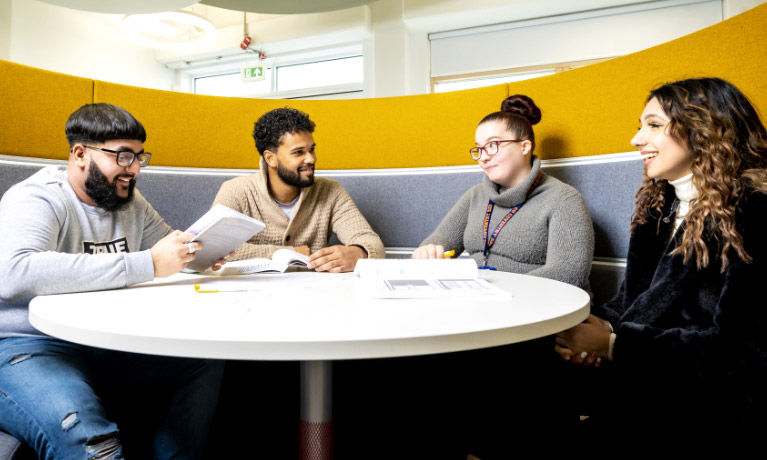 Group of students around a table talking