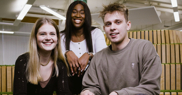 Three students smiling at the camera