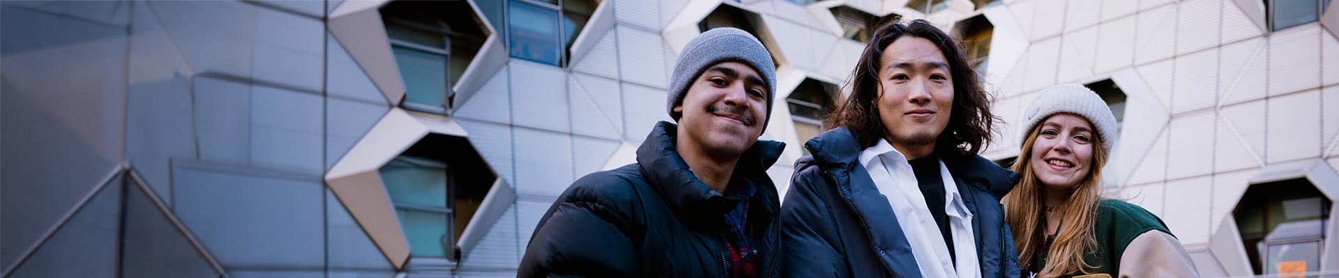 three students stood outside of the Sir Frank Whittle building