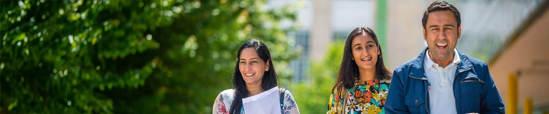 Student and parents walking outside on campus