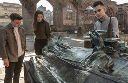Students looking at a sculpture in the Coventry Cathedral ruins