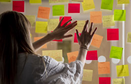 A student looking at a wall of sticky notes