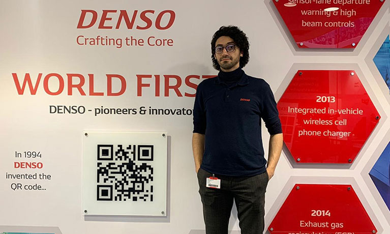 Hameed in front of a Denso banner