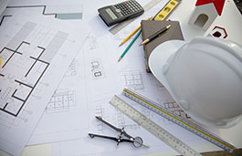 Architectural plan with stationery and hard hat on the side
