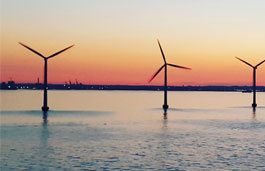 Wind turbines in the sea at sunset.